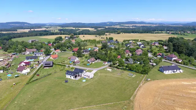 Jivina z dronu: novostavby mezi poli, vpravo dole sklizené pole