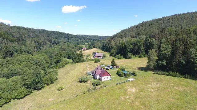 Slavíkov: dům s červenou střechou na louce v údolí